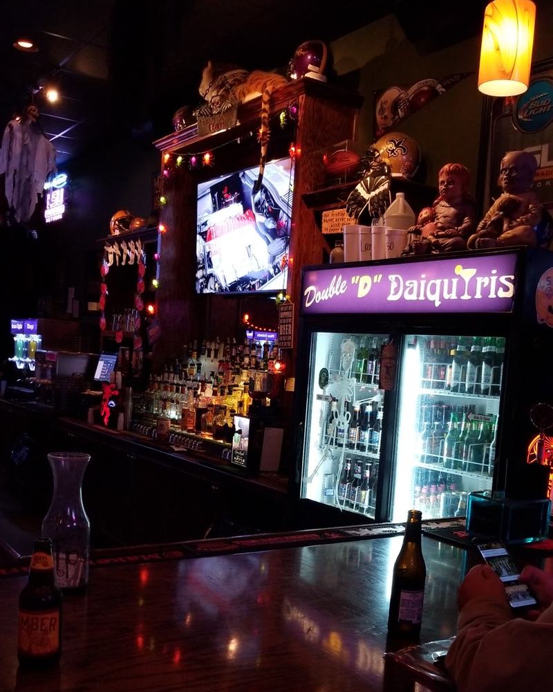 The bar at night under the lit Double D Daiquiris sign over the cooler