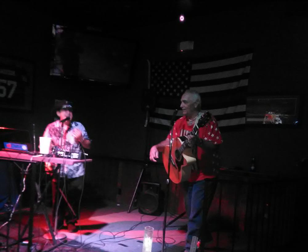 A keyboard and guitar duo playing on the stage